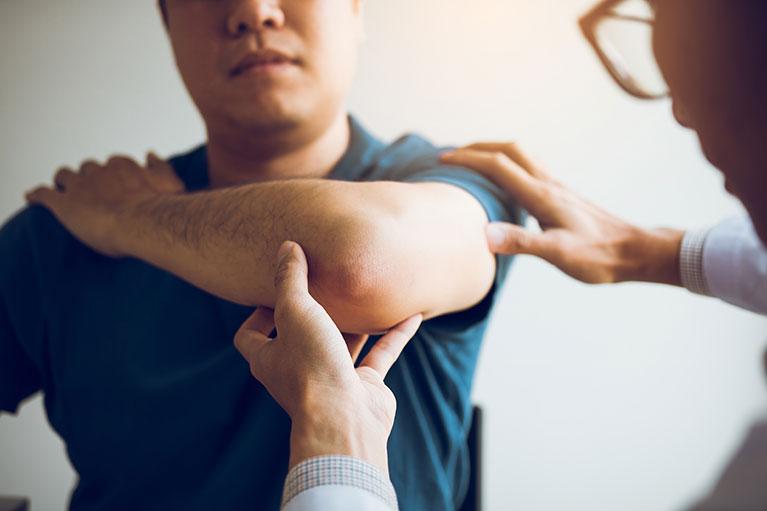 A chiropractor evaluating a patient's arm