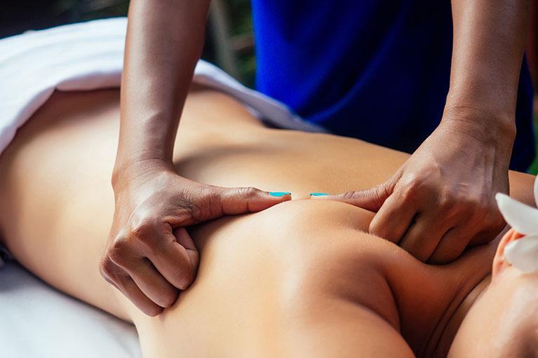 Massage Therapist working on a patient's back and shoulders